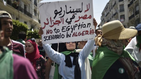 An Algerian woman raises a placard as she takes part in a weekly demonstration in the capital Algiers on June 14, 2019. (AFP/ File Photo)