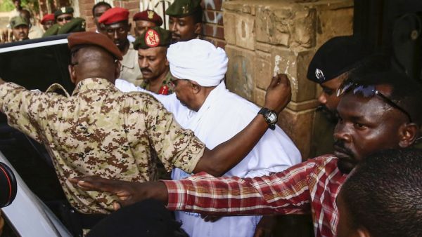 Sudan's ousted president Omar al-Bashir (C) is escorted into a vehicle as he returns to prison following his appearance before prosecutors over charges of corruption and illegal possession of foreign currency, in the capital Khartoum on June 16, 2019.  (AFP/ File Photo)