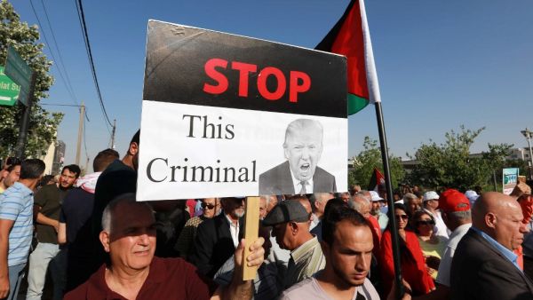A protester holds an anti-Donald Trump sign as he marches with others during the "March of Anger" demonstration leading to the US embassy headquarters in the Jordanian capital Amman on June 21, 2019, against US President Donald Trump's "Deal of the Century" and the US-led Middle East economic conference in Bahrain.  (Khalil MAZRAAWI / AFP)