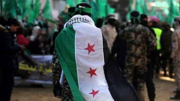 احد قادة القسام يغطي نفسه بعلم الثورة السورية في مسيرة للحركة في غزة 