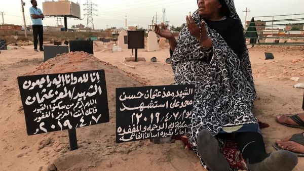 Khadom, the mother of Al-Moez visits the tomb of her son, killed when a bullet pierced the window of his workplace and lodged itself in his heart during an anti-government demonstration in the Sudanese capital Khartoum in April, on July 9, 2019. (AFP/ File Photo)