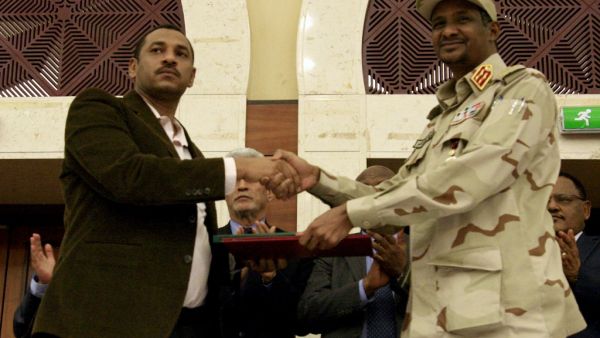 Sudanese deputy chief of the ruling miliary council Mohamed Hamdan Dagalo (R) and protest movement Alliance for Freedom and Changes leader Ahmad al-Rabiah shake hands after inking an agreement before African Union and Ethiopian mediators in Khartoum early on July 17, 2019. (AFP/ File Photo)