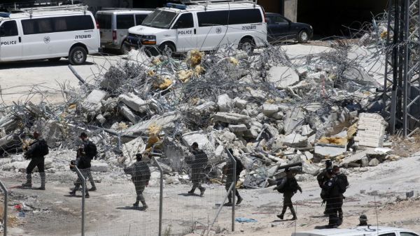 West Bank village of Dar Salah shows Israeli security forces walking past the rubble of a house that underwent a demolition in the area of Sur Baher in East Jerusalem (AFP)
