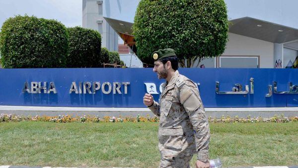 A Saudi serviceman walks by a sign outside Abha airport. (AFP)