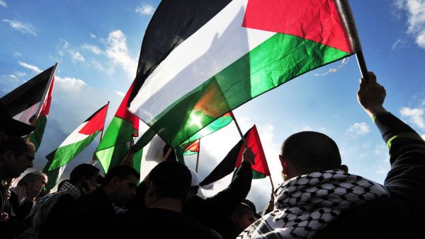 Palestinians carry Palestinians flags (Shutterstock)	
