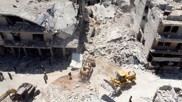 In this aerial picture, members of the Syrian civil defence, known as the White Helmets use an excavator to search for victims under the rubble following a reported Russian air strike on Maaret al-Numan in Syria's northwestern Idlib province on July 22, 2019 .(AFP/ File Photo)