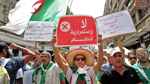Algerian protesters hold posters as they demonstrate in Algiers on August 2, 2019, for the 24th consecutive Friday against the ruling class amid an ongoing political crisis in the country. (AFP)