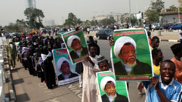 Members of Islamic Movement in Nigeria take part in a demonstration against the detention of their leader Ibrahim Zakzaky (poster), in Abuja (AFP)