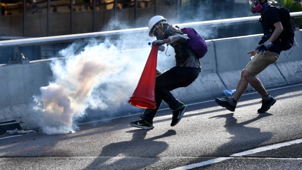 A protester preparing to cover a tear gas canister fired by the police with a traffic cone in the Admiralty district of Hong Kong during a general strike, as simultaneous rallies were held across seven districts.  (AFP/ File Photo)