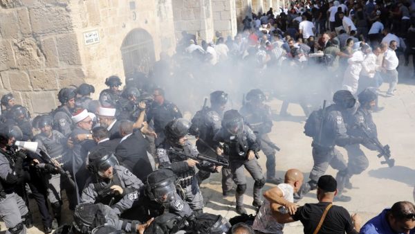Israeli security forces fire sound grenades inside the Al-Aqsa Mosque compound in the Old City of Jerusalem on August 11, 2019, as clashes broke out during the overlapping Jewish and Muslim holidays of Eid al-Adha and the Tisha B'av holdiay. (AFP)