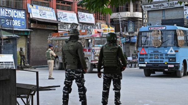 Security personnel stand guard a street during a lockdown in Srinagar on August 12, 2019. (AFP)