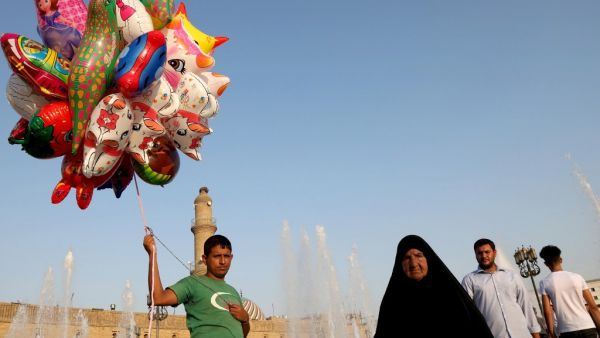 An Iraqi Kurdish man sells balloons on the central square near the citadel of Arbil, the capital of the autonomous Kurdish region of northern Iraq, as people celebrate the Muslim religious festival of Eid al-Adha on August 13, 2019. (AFP/ File Photo)
