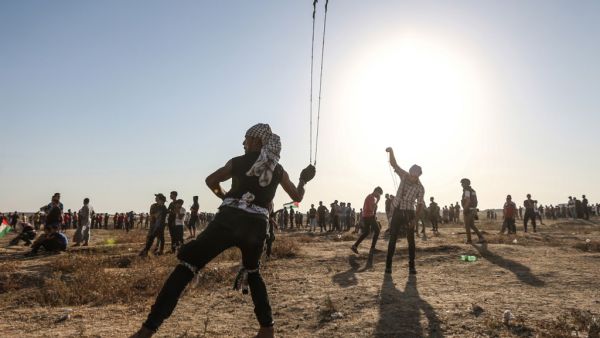 A Palestinian protester uses a slingshot to hurl stones during clashes with Israeli forces near the fence along the border with Israel in the eastern Gaza Strip on August 16, 2019.  (MAHMUD HAMS / AFP)