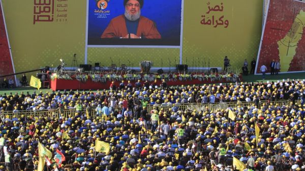 Hasan Nasrallah, the head of Lebanon's militant Shiite movement Hezbollah, delivers a speech on a screen during a commemoration marking the 13th anniversary of the end of the 2006 war with Israel in the southern Lebanese town of Bint Jbeil on August 16, 2019. (AFP)