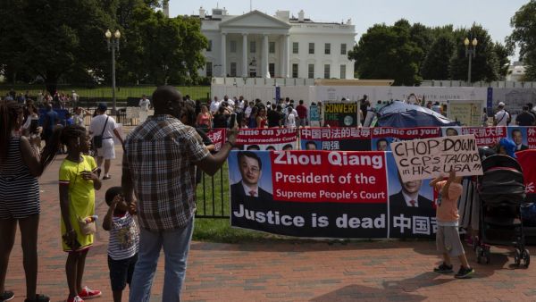 A man (L) takes photos of a child (R) in support of the ongoing demonstrations in Hong Kong as they protest at Lafayette Square outside the White House in Washington, DC, on August 18, 2019. (AFP/ File Photo)