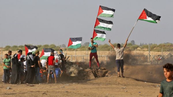 Palestinian demonstrators wave the national flag during clashes between Palestinian protesters and Israeli forces. (AFP/ File Photo)