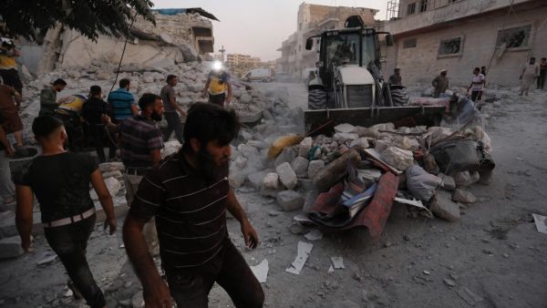 Members of the Syrian Civil Defence (White Helmets) clear debris during their search for survivors following a reported airstrike