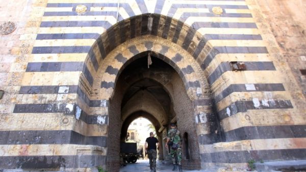 Syrian government soldiers walk through the entrance to the Khan al-Wazir market in Aleppo on September 16, 2016. (AFP/ File Photo)