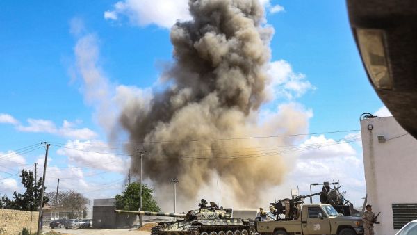 smoke plume rising from an air strike behind a tank and technicals (pickup trucks mounted with turrets) belonging to forces loyal to Libya's Government of National Accord (GNA). (AFP/ File Photo)