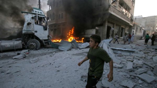 A young boy runs past a fire started in a building following a reported airstrike by Syrian regime forces in the town of Maaret al-Numan in Syria's northwestern Idlib province on August 28, 2019. (AFP/ File Photo)