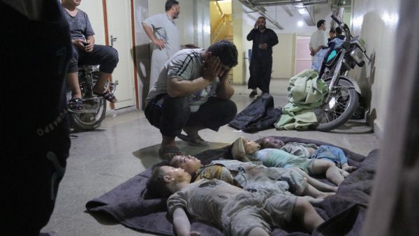 A man mourns over the bodies of his three children and their cousin at a morgue in the basement of a makeshift hospital following a reported airstrike by Syrian regime forces in Maaret al-Numan in Syria's northwestern Idlib province on August 28, 2019. (Zein Al RIFAI / AFP)