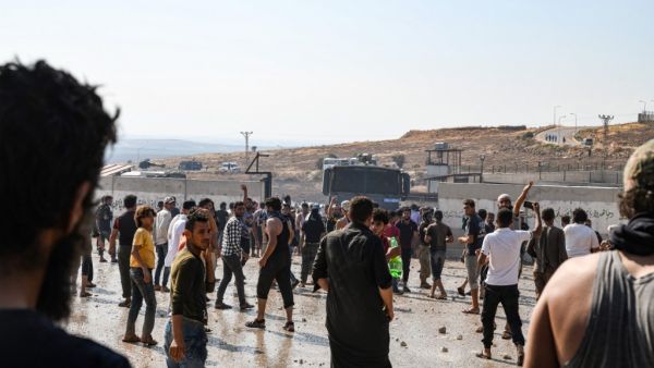 Displaced Syrians demonstrate along the border with Turkey near the town of Atme in the northwestern Idlib province (AFP)