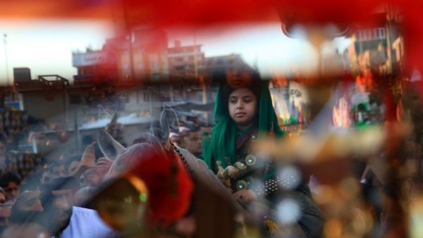 A young boy parades on horeseback as Iraqi Shiite Muslims gather during a ceremony marking the 7th day of Muharram as part of Ashura in the central Iraqi city of Karbala  (AFP)