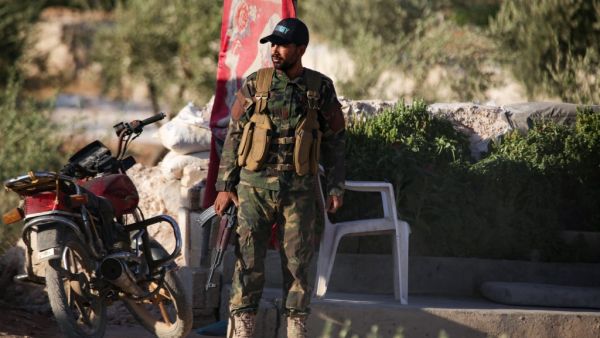 A Turkish-backed Syrian fighter stands guard on the outskirts of Syria's northern town (AFP)