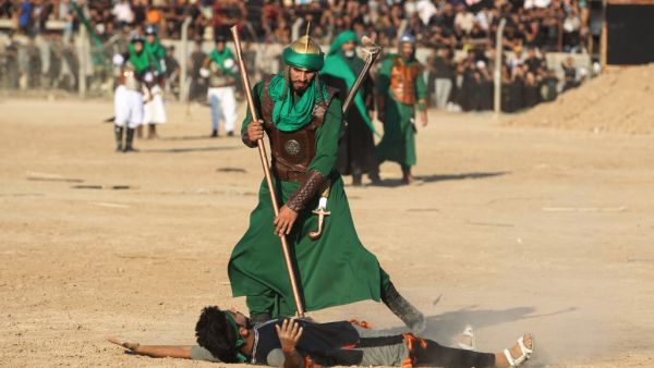 Iraqi Shiite Muslims costumes re-enact events of Ashura, in Baghdad's predominantly Shiite Sadr City (AFP)