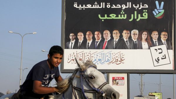 Electoral billboard for the Popular Unity party with its candidates and a slogan in Arabic reading "the decision of the people", in the Bedouin town of Rahat near the southern Israeli city of Beersheba. HAZEM BADER / AFP
