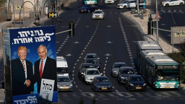 Traffic drives past an Israeli election billboard for the Likud party, showing US President Donald Trump (L) shaking hands with Likud chairman and Prime Minister Benjamin Netanyahu in Jerusalem AHMAD GHARABLI / AFP