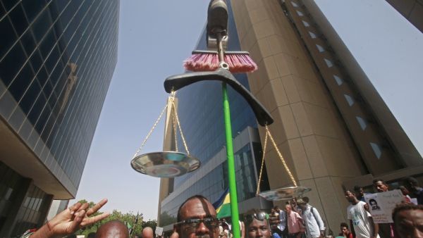 A Sudanese protester carries makeshift scales during a protest asking for the extradition of ousted former president Omar al-Bashir to the International Criminal Court in the capital Khartoum on September 19, 2019. (ASHRAF SHAZLY / AFP)