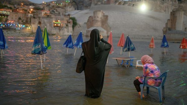 A woman takes a picture of the 12,000 year old ancient city of Hasankeyf, on the banks of the Tigris, in southeastern Turkey on August 17, 2019. (AFP)