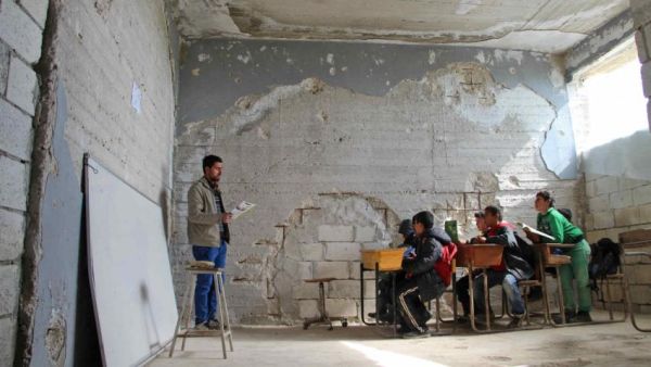 Children attend a class in a school in Idlib that was partially destroyed [AFP/Getty]