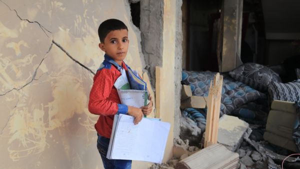 A Yemeni child stands in the middle of his destroyed house because of a rocket. (Shutterstock/ File Photo)