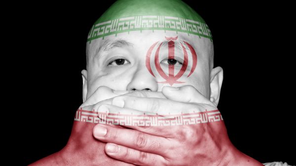 A man covering his mouth with his hand with imprint of Iran flag (Shutterstock)	