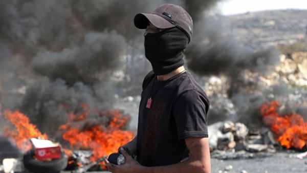 A Palestinian protester watches during clashes with Israeli security forces at the entrance of the West Bank city of Ramallah close to the Jewish settlement of Beit El, following a demonstration to show solidarity with Palestinian prisoners held in Israeli jails on October 1, 2019. (ABBAS MOMANI / AFP)