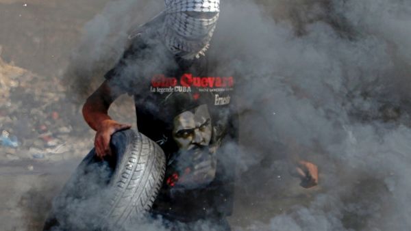 A Palestinian protester burns tyres during clashes with Israeli security forces at the entrance of the West Bank city of Ramallah close to the Jewish settlement of Beit El, following a demonstration to show solidarity with Palestinian prisoners held in Israeli jails on October 1, 2019. (ABBAS MOMANI / AFP)