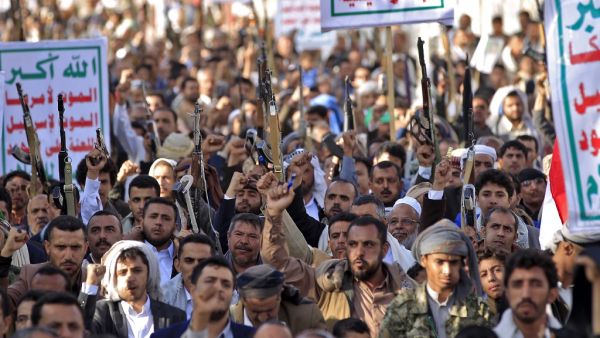 Supporters of Yemen's Shiite Huthi rebels chant slogans and raise Kalashnikov assault rifles and signs showing the group's flag, reading in Arabic "God is Great, death to America, death to Israel, curse upon the Jews, victory to Islam", as they gather for a rally in support of the group in the Huthi-held capital Sanaa on October 4, 2019. (MOHAMMED HUWAIS / AFP)