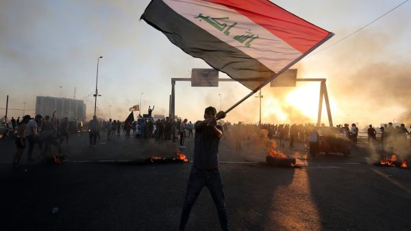 An Iraqi protester waves the national flag during a demonstration against state corruption, failing public services, and unemployment, in the Iraqi capital Baghdad on October 5, 2019. (AFP/ File Photo)