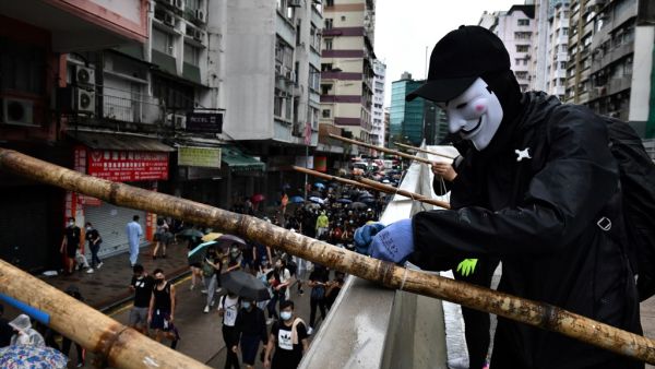 A protester uses bamboo scaffolding to make a road block as others take part in a march through the Tsim Sha Tsui area of Hong Kong on October 6, 2019. (AFP/ File Photo)