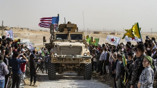 Syrian Kurds gather around a US armoured vehicle during a demonstration against Turkish threats next to a US-led international coalition base on the outskirts of Ras al-Ain town in Syria's Hasakeh province near the Turkish border on October 6, 2019. (AFP/ File Photo)