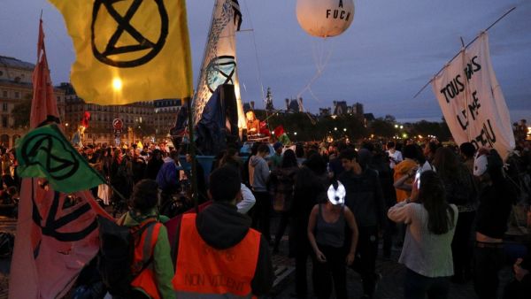 Protesters dance on the Pont au Change bridge as they take part in a demonstration called by climate change activist group Extinction Rebellion, on October 7, 2019 in front of the Conciergerie in Paris. (AFP/ File Photo)