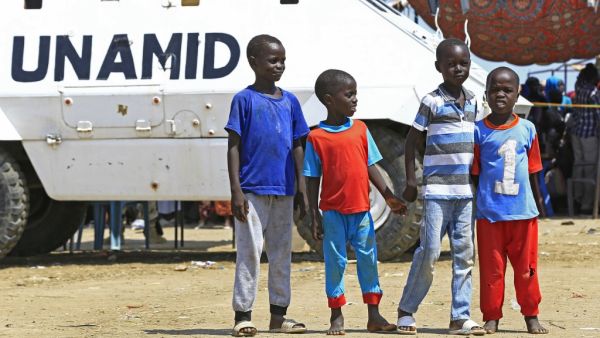Displaced Sudanese boys pose for a picture in front of a UN-African Union mission to Darfur (UNAMID) vehicle at the Kalma camp for internally displaced people in Darfur's state capital Niyala on October 9, 2019. (AFP/ File)
