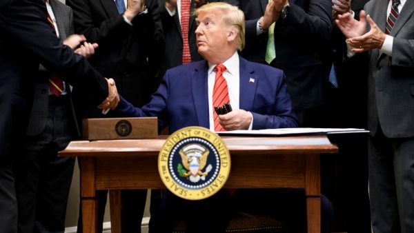 US President Donald Trump shakes hands after signing an executive order regarding federal regulations in the Roosevelt Room of the White House October 9, 2019, in Washington, DC. (Brendan Smialowski / AFP)