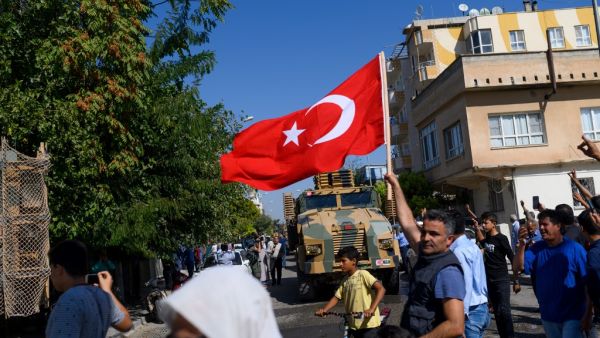 A man waves a Turkish flag as Turkey-backed Syrian opposition fighters enter Tel Abyad from Turkish gate towards Syria in Akcakale in Sanliurfa province on October 10, 2019. (AFP/ File Photo)