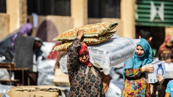 A displaced Syrian woman, who fled her home in the border town of Ras al-Ain, receives humanitarian aid on October 12, 2019, in the town of Tal Tamr in the countryside of Syria's northeastern Hasakeh province. (Delil SOULEIMAN / AFP)