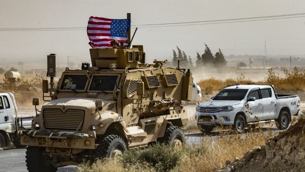 In this file photo taken on October 6, 2019 a US soldier sits atop an armoured vehicle during a demonstration by Syrian Kurds against Turkish threats next to a base for the US-led international coalition on the outskirts of Ras al-Ain town in Syria's Hasakeh province near the Turkish border. (AFP/ File Photo)