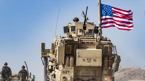 In this file photo taken on October 6, 2019 a US soldier sits atop an armoured vehicle during a demonstration by Syrian Kurds against Turkish threats next to a base for the US-led international coalition on the outskirts of Ras al-Ain town in Syria's Hasakeh province near the Turkish border. (Delil SOULEIMAN / AFP)