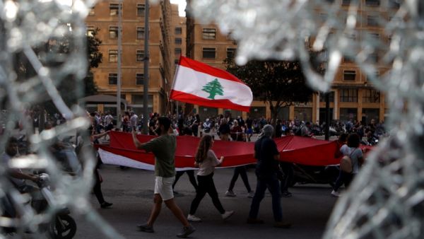 Lebanese demonstrators waving a national flag as they take part in a protest in the capital Beirut's the downtown district (AFP)